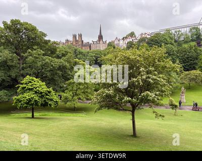 Lussureggiante parco pubblico con prati curati ed edifici in pietra nei Princes Street Gardens, Edimburgo, Scozia. Foto Stock