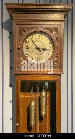 Orologio da parete vintage in legno con pendolo e pesi da primo piano, per interni antichi, concetti che passano il tempo, collezioni Heritage, artigianato classico Foto Stock