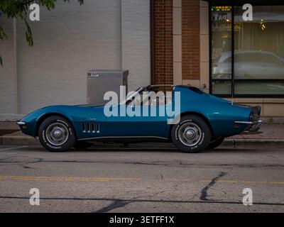 Classica auto sportiva Chevrolet Corvette Stingray d'epoca blu parcheggiata in una strada del centro accanto agli edifici in una giornata limpida Foto Stock