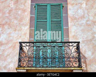 Un tipico balcone italiano con reticolo aperto e persiane chiuse in legno verde Foto Stock