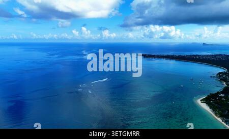 Vista aerea delle acque turchesi, delle barriere coralline e della costa sabbiosa con piccole barche ancorate vicino alla riva sotto un cielo blu a Trou-aux-Biches, Pample Foto Stock