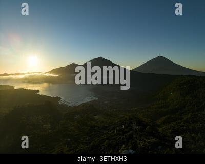 Vista aerea del lago Batur all'alba con montagne lussureggianti e acque calme a Kintamani, Bali, Indonesia. Foto Stock