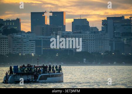 Rio de Janeiro, Rio de Janeiro, Brasile - 20 giugno 2026: Vista di un catamarano affollato che naviga sull'acqua con lo skyline della città di Rio de Janeiro nella ba Foto Stock