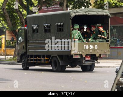 Hanoi, Vietnam - 11 novembre 2025: Veduta del personale militare in uniforme seduto sul retro di un camion di trasporto verde vicino alla Cittadella Imperiale di T Foto Stock