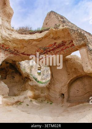 Antichi affreschi religiosi sbiaditi dipinti sul soffitto di una chiesa rupestre scolpita nella storica regione della Cappadocia in Turchia. Foto Stock