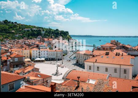 Vista panoramica di Pirano, Slovenia, con Piazza Tartini, porticciolo e costa adriatica sotto il blu del cielo estivo. Foto Stock