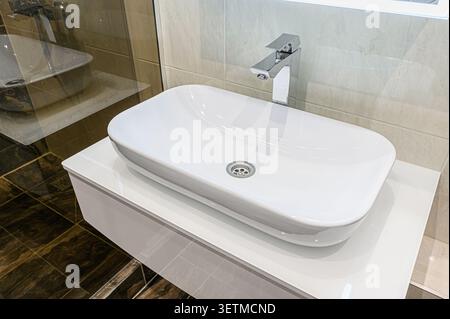 Bagno moderno con elegante lavabo rettangolare bianco con rubinetto cromato Foto Stock