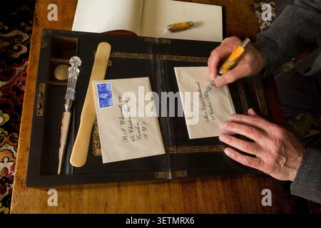 Scrivere una lettera a mano su una vecchia scatola per scrivere lettere Foto Stock