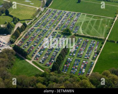 Vista aerea del campo coltivato in erba utilizzato come parcheggio con file di auto parcheggiate. Parcheggio auto organizzato ed economico in un campo agricolo Foto Stock