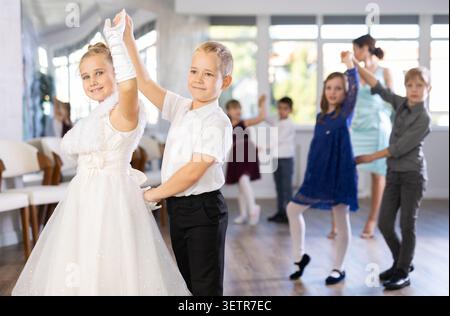 Danze classiche eseguite da bambini preadolescenti in abiti festivi Foto Stock