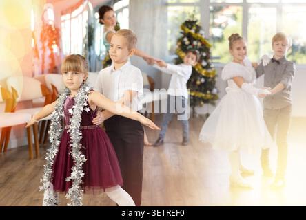 Spettacolo di Capodanno - i bambini vestiti splendidamente ballano balli classici al ballo di Natale Foto Stock