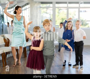Danze classiche eseguite da bambini preadolescenti in abiti festivi Foto Stock