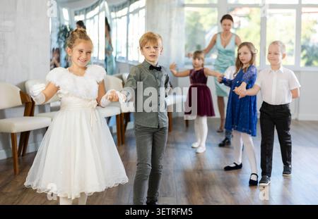 Gruppo di bambini preadolescenti movimenti di valzer in studio di danza Foto Stock