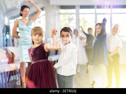 Danze classiche eseguite da bambini preadolescenti in abiti festivi Foto Stock