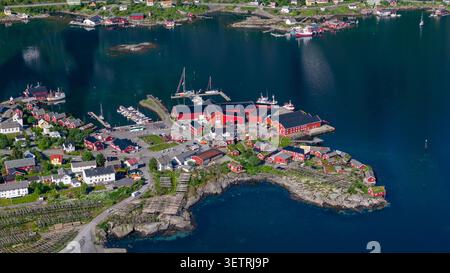 Vista aerea panoramica del tradizionale villaggio di pescatori delle isole Lofoten con caratteristiche case rosse, moli di legno, barche a vela e rocce Foto Stock