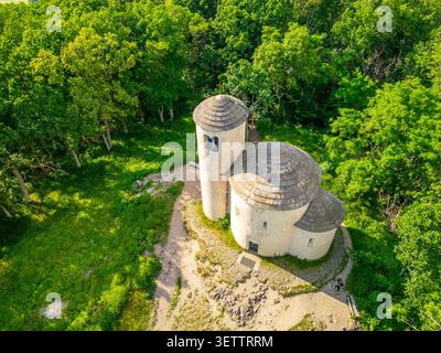 I visitatori esplorano l'antica Rotonda di San Giorgio sul Monte Rip, circondata da alberi verdi. La struttura presenta due torri distinte ed è un sito storico che attrae turisti. Foto Stock