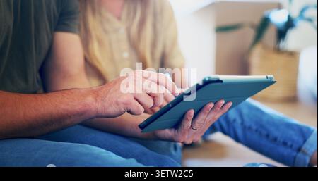Coppia, mani e pianificazione in una nuova casa con tablet, shopping online e ricerca per l'interior design. Persone sposate, che navigano e si trasferiscono a casa Foto Stock