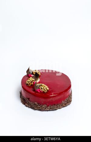 Una foto pubblicitaria ad alto angolo che mostra una mousse cake gourmet con finitura lucida impeccabile, scaglie di cioccolato e intricati condimenti di noci spolverati d'oro Foto Stock