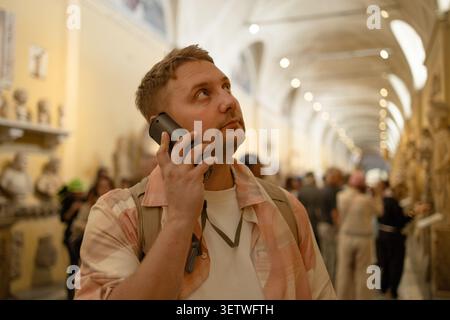Giovane turista di sesso maschile che ascolta l'audioguida nel museo storico Foto Stock