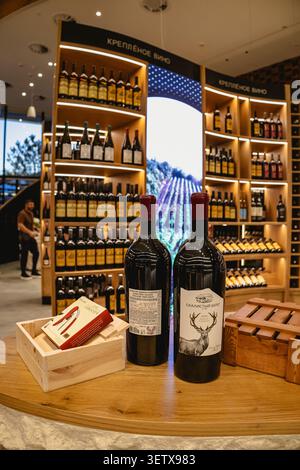 Gelendzhik, Russia - 14 giugno 2026: Apertura della città del vino di Capo bianco. Due grandi bottiglie di vino con etichetta di cervo sul banco di legno. fe. Sfondo Foto Stock