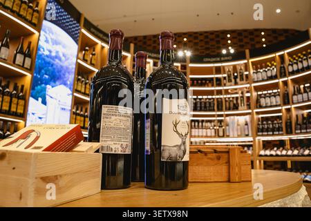 Gelendzhik, Russia - 14 giugno 2026: Apertura della città del vino di Capo bianco. Due grandi bottiglie di vino con etichetta di cervo sul banco di legno. fe. Sfondo Foto Stock