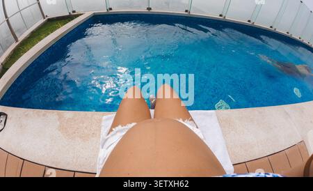 Donna incinta che si gode una vacanza estiva presso una piscina sul tetto Foto Stock