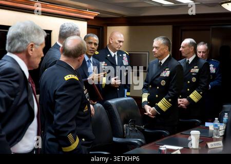 Il presidente Barack Obama parla con i capi di Stato maggiore congiunti a seguito di una riunione nella Situation Room della Casa Bianca, 28 ottobre 2014. In piedi con il presidente da sinistra sono: Il segretario alla difesa Chuck Hagel; il generale Martin Dempsey, presidente del Joint Chiefs of staff; Robert Work, vice segretario alla difesa; il generale Raymond Odierno, capo di stato maggiore dell'esercito; l'avvocato James A. Winnefeld, Jr., vice presidente del Joint Chiefs of staff; l'avvocato Jonathan Greenert, capo delle operazioni navali; e il generale Mark Welsh, capo di stato maggiore dell'aeronautica. (Foto ufficiale della Casa Bianca di Pete Souza) questo Whit ufficiale Foto Stock