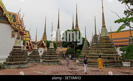 Turisti che esplorano gli antichi stupa e il complesso del tempio di wat Pho a bangkok Foto Stock