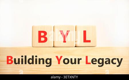 BYL sta costruendo il tuo simbolo legacy. Parole concettuali BYL costruisce la tua eredità su splendidi blocchi di legno. Splendido sfondo bianco. Business BYL Building Foto Stock