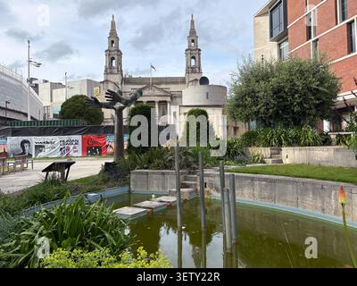 Leeds Civic Hall sullo sfondo con una scultura in bronzo e un laghetto ornamentale nella piazza del millennio, Leeds Regno Unito. Foto Stock