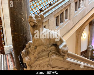 Una dettagliata scultura di leone in pietra montata su una banister di scale all'interno della Leeds Central Library, Leeds, West Yorkshire, Inghilterra. Foto Stock