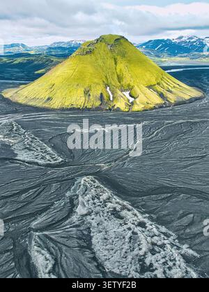 Veduta aerea del vulcano Maelifell ricoperto di muschio verde che sorge dalle pianure vulcaniche nere di sabbia di Maelifellssandur a Kirkjubaejarklaustur, Skafta Foto Stock