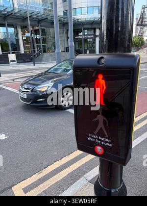 Il pulsante di controllo del semaforo pedonale mostra un segnale MAN rosso a Leeds, Regno Unito. Foto Stock