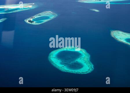 Vista aerea dell'atollo a forma di cuore e delle barriere coralline delle Maldive Foto Stock