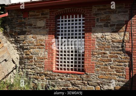 Finestra barrata con mattoni rossi che circonda uno storico edificio in pietra a Reeder's Alley, Helena, Montana. Foto Stock