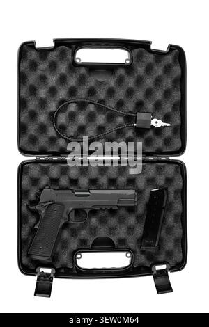 Pistola semi-automatica nera con caricatore e blocco cavo all'interno di una custodia in plastica rigida imbottita in schiuma. Foto Stock