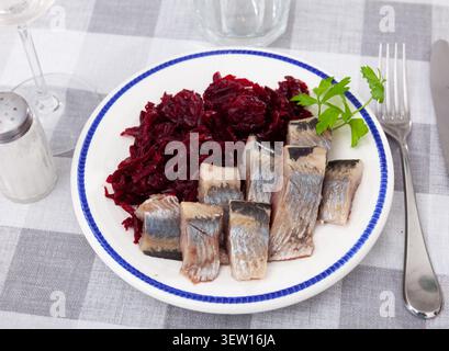 Pezzi di aringhe tritate con barbabietole servite sul piatto Foto Stock