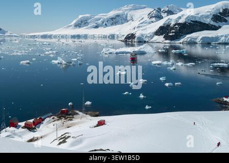 Vista aerea della Brown Station, la base di ricerca antartica argentina sulla penisola antartica, circondata da iceberg galleggianti con una nave da crociera Foto Stock