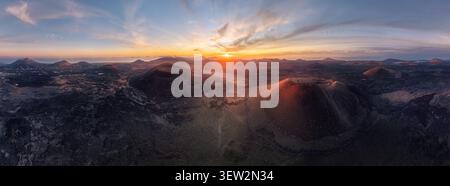 Spettacolare vista panoramica aerea del paesaggio vulcanico di Lanzarote all'alba, con spettacolari crateri, campi di lava e cieli colorati nel Cana Foto Stock