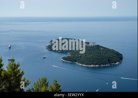 Vista ad angolo alto dell'isola boscosa di Lokrum circondata dal calmo Mar Adriatico durante il giorno a Dubrovnik, Croazia. Foto Stock