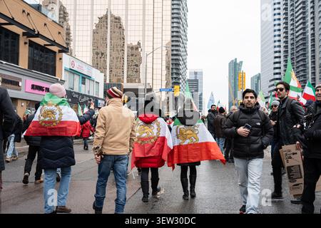 Toronto, Ontario - 14 febbraio 2026: Raduno della diaspora iraniana con bandiere su Yonge Street Foto Stock