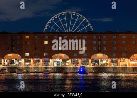 Albert Dock, Liverpool, di notte, con la ruota di Liverpool sullo sfondo Foto Stock