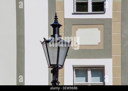Lampada da strada decorata in ghisa nera su una facciata storica verde e bianca Foto Stock