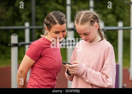 Madre e figlia che guardano uno smartphone insieme Foto Stock