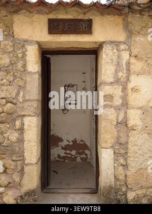 Vecchia cabina telefonica pubblica incastonata in un muro di pietra che conserva l'originale cartello in legno nella città medievale di Pedraza, Segovia, Spagna. Foto Stock