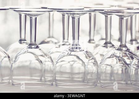 Primo piano di bicchieri da vino trasparenti capovolti in fila Foto Stock