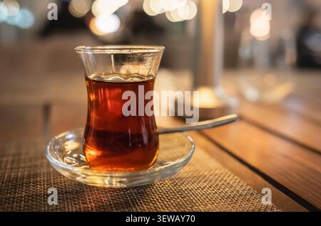 Da vicino una tazza di tè nero caldo, bevanda calda tradizionale turca preparata su un tavolo di legno servito al ristorante. Nessuno, concentrazione selettiva Foto Stock