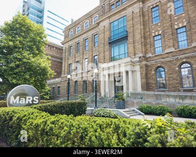 L'edificio storico del quartiere della scoperta MaRS si trova in College Street a Toronto, caratterizzato da finestre ad arco, architettura in mattoni e un prominente MaRS Foto Stock