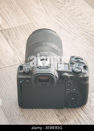 Una fotocamera senza specchio Canon EOS R5 con obiettivo zoom RF 24–240mm poggia su una superficie di legno. Foto Stock