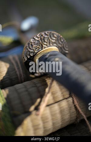 Prima vista di una spada samurai tradizionale giapponese (katana) appoggiata su tatami pronta per l'allenamento di taglio tameshigiri a Okinawa, Giappone Foto Stock